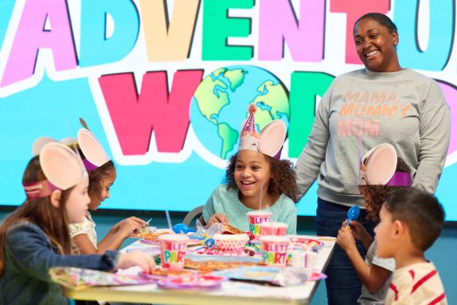 A birthday star and her guests around a decorated party table at Adventure World