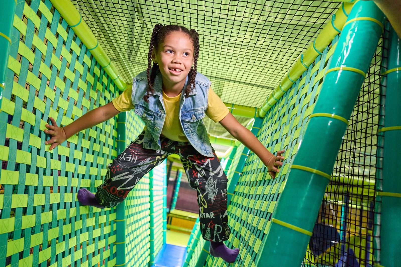 A girl climbing through the rope netting inside the Adventure World play structure
